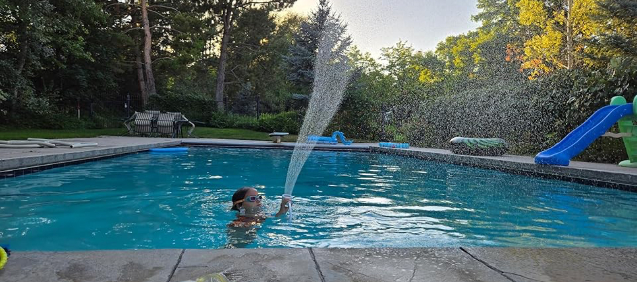 Child using the portable shower in a pool